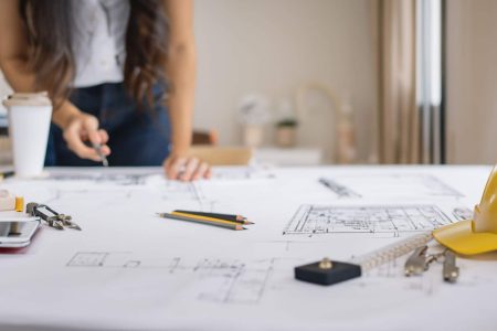 Architetto che disegna planimetria per relazione tecnica di vendita immobiliare