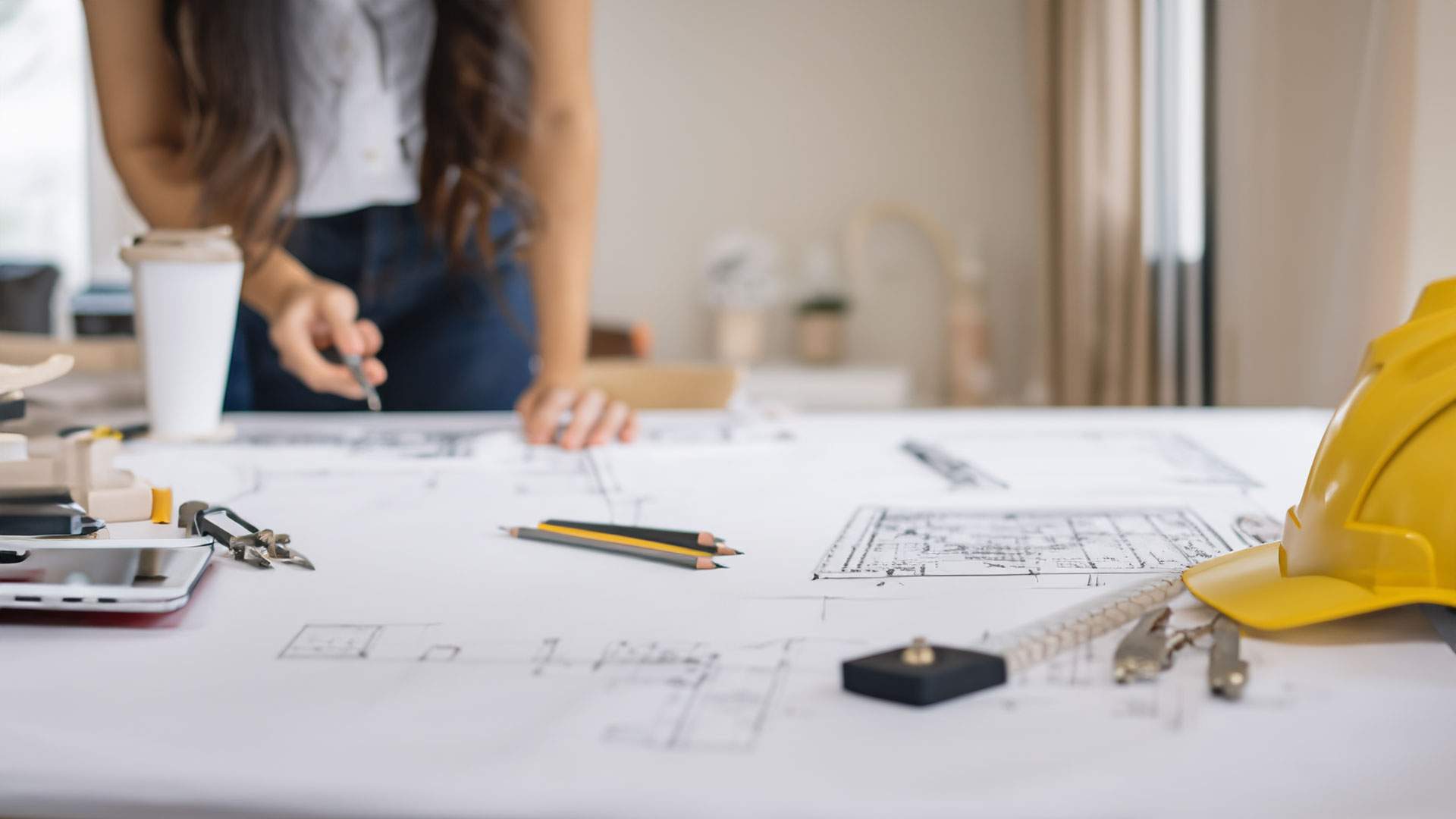 Architetto che disegna planimetria per relazione tecnica di vendita immobiliare